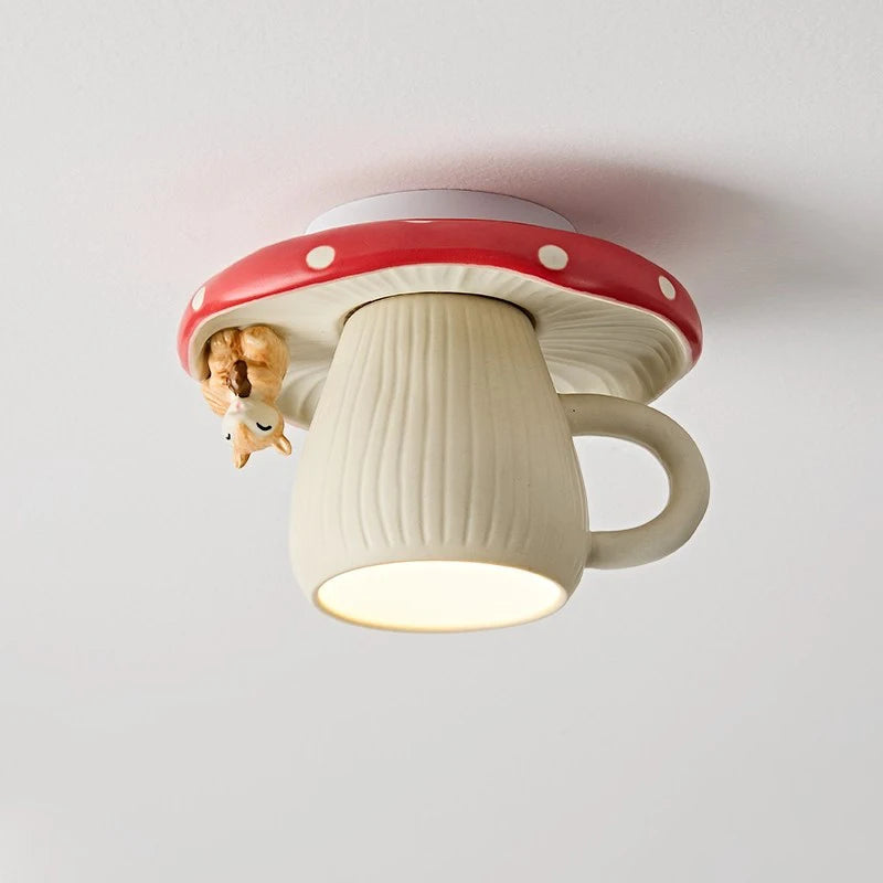 Close-up of a red and white mushroom-shaped ceiling light with a small squirrel hanging off the side, illuminating downwards.