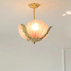 Close-up of a pink shell-shaped glass pendant light with ornate gold leaf accents, illuminated from within.