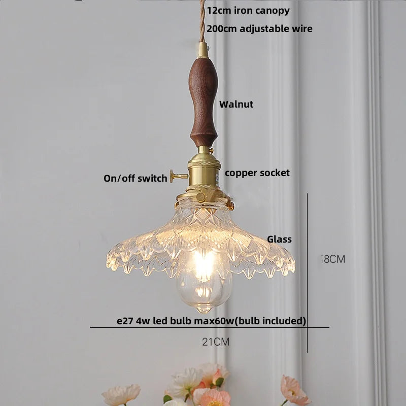 Vintage-style pendant light with clear glass shade and wooden handle on a neutral background.