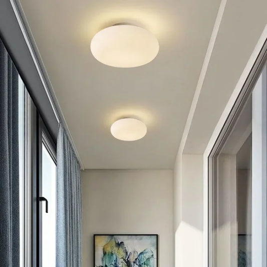 Two white flush mount ceiling lights illuminating a modern hallway