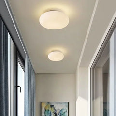 Two white flush mount ceiling lights illuminating a modern hallway