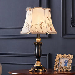 Close-up of the ornate table lamp base, showing the distressed teal and gold finish with carved details.