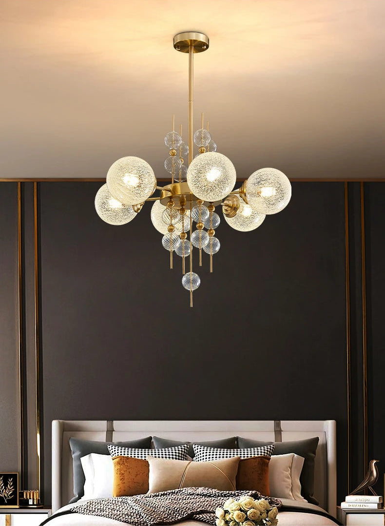 Modern chandelier hanging above a bed with a dark wall background