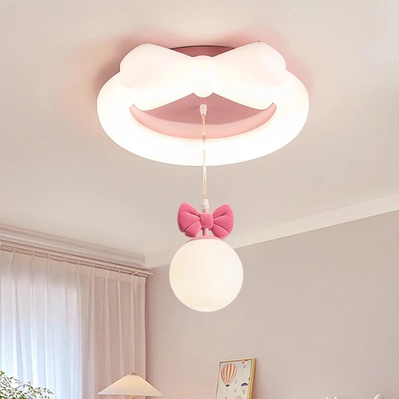 Close-up of the white ceiling light with pink bow, showing the integrated LED ring and the hanging orb light with pink bow detail.