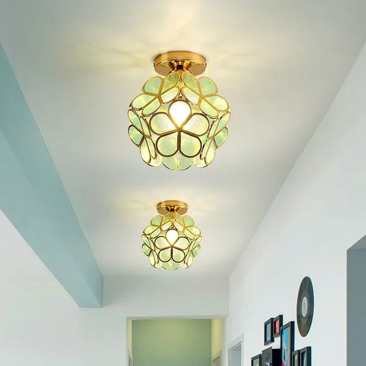 Two gold flush mount ceiling lights with acrylic petals illuminating a hallway with a soft glow.