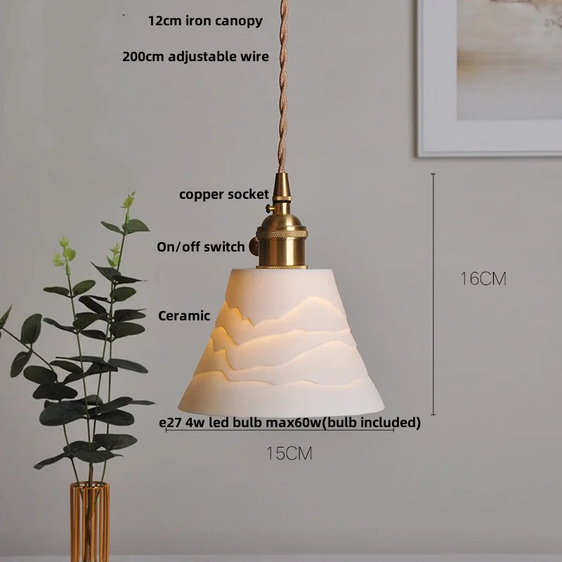 Pendant light with ceramic shade, brass canopy, and adjustable wire on a neutral background.