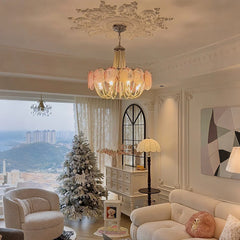 A festive living room scene with a gold beaded chandelier and a decorated Christmas tree.