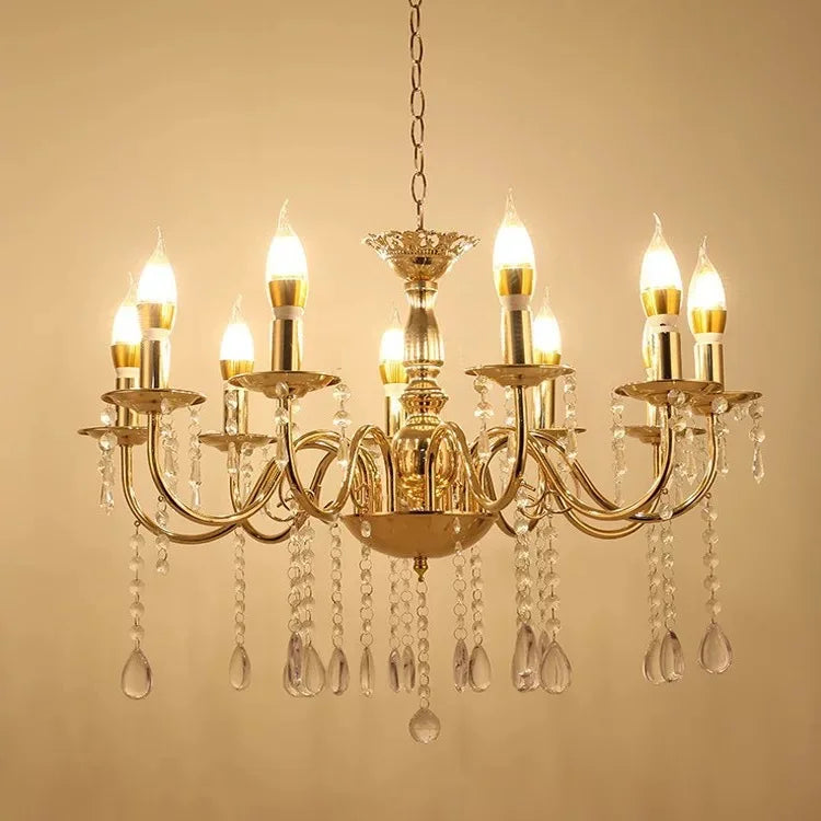 A wide shot of a gold chandelier with multiple tiers and arms, detailed with numerous crystal strands and drops, emitting a warm glow.