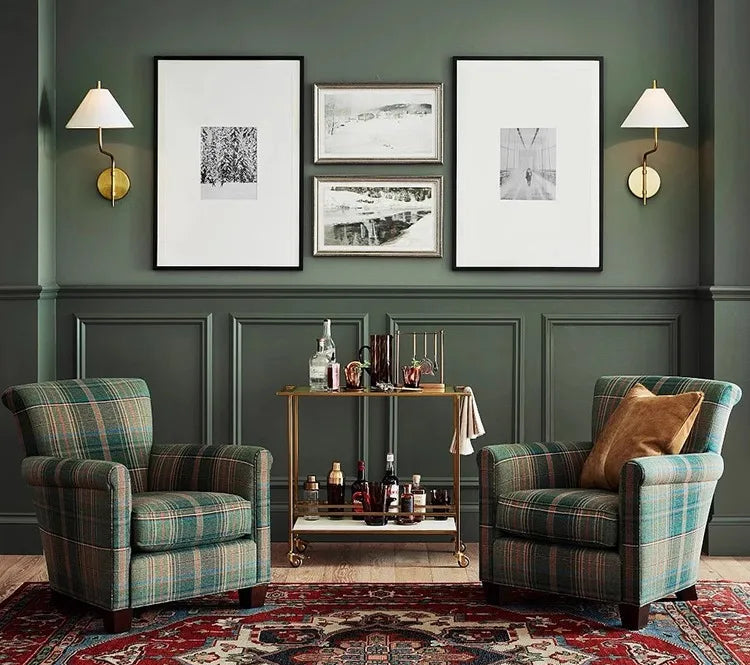 Living room with plaid armchairs, a coffee table, and framed pictures on a green wall.