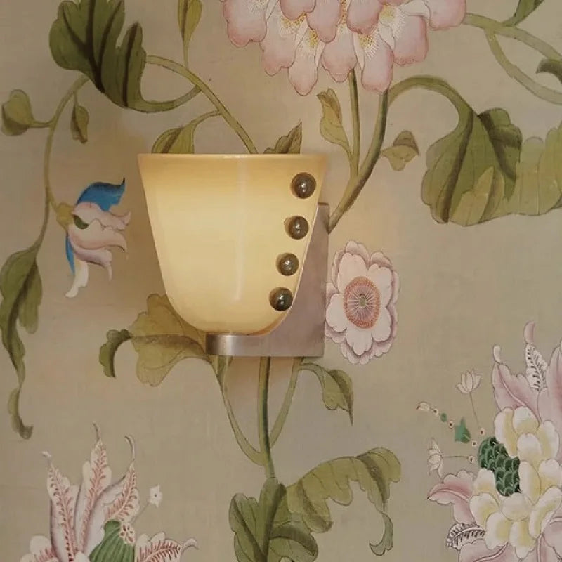 Wall sconce with floral wallpaper in the background