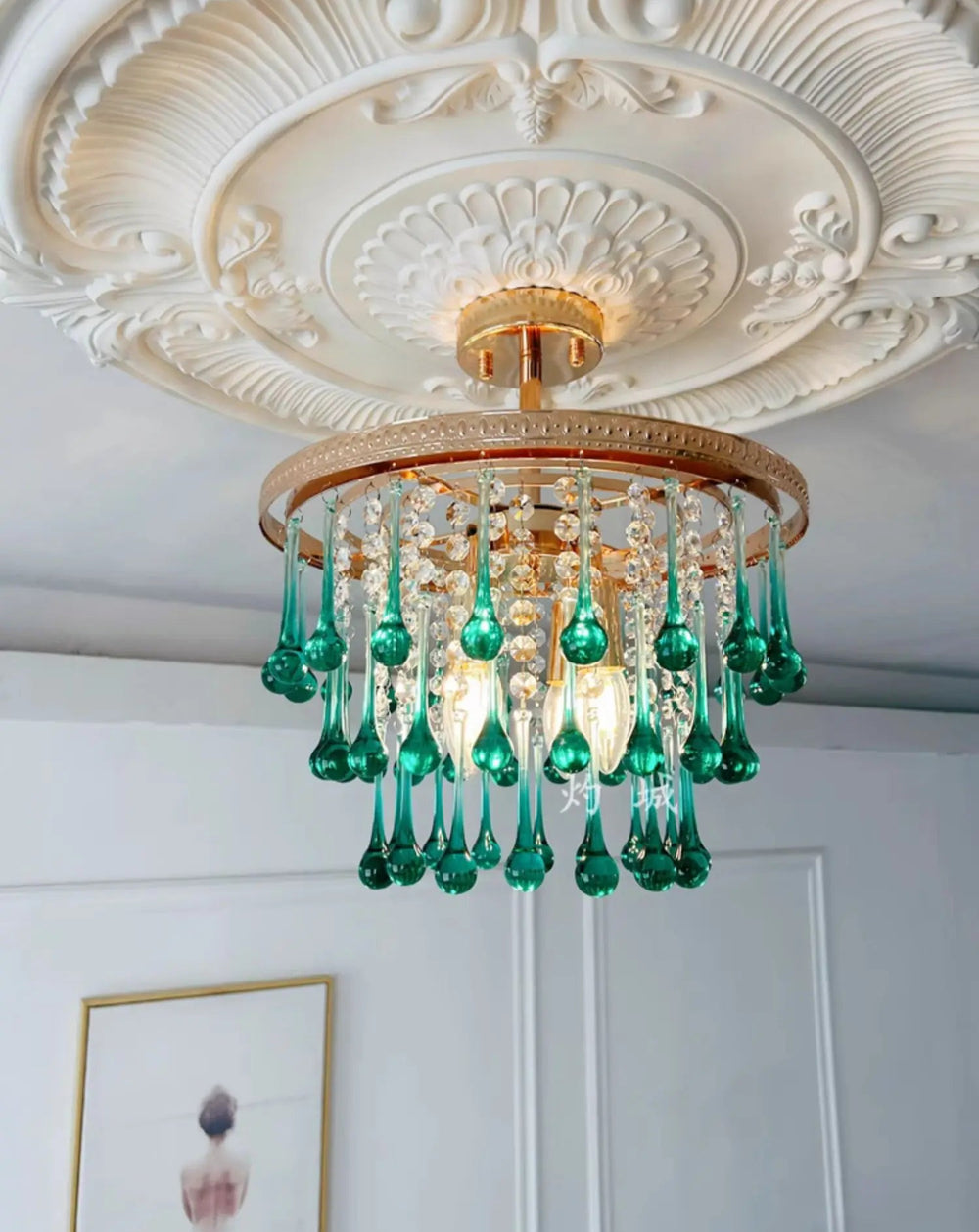 Decorative chandelier with green glass elements hanging from a ornate ceiling.