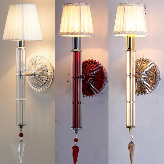 Champagne crystal wall sconce with a tiered design and fabric shade, illuminated.