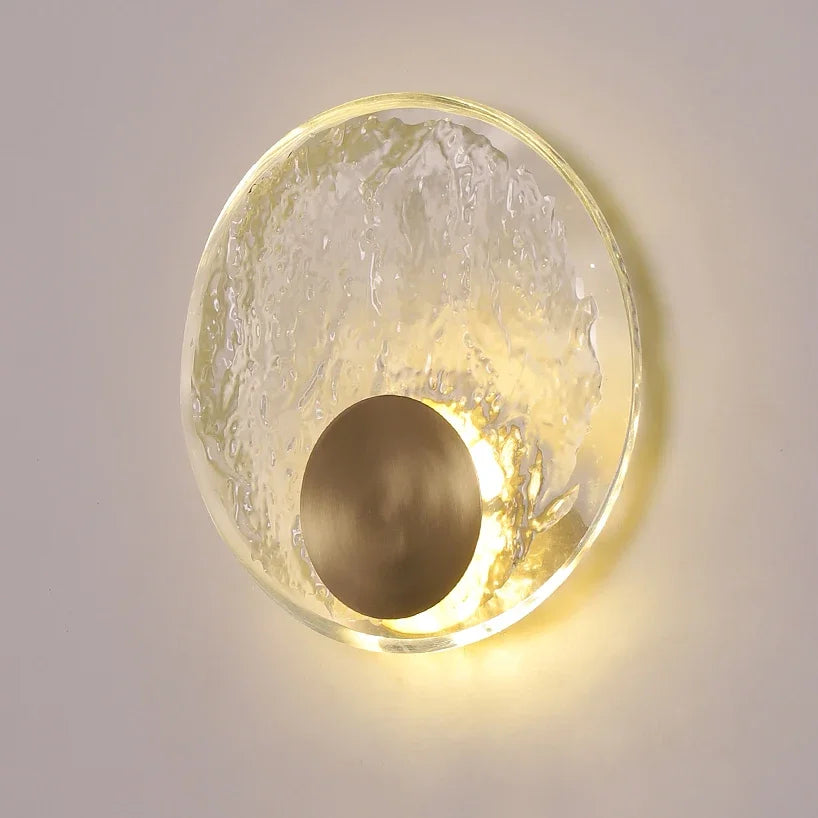 Round wall light fixture with textured glass cover on a neutral background