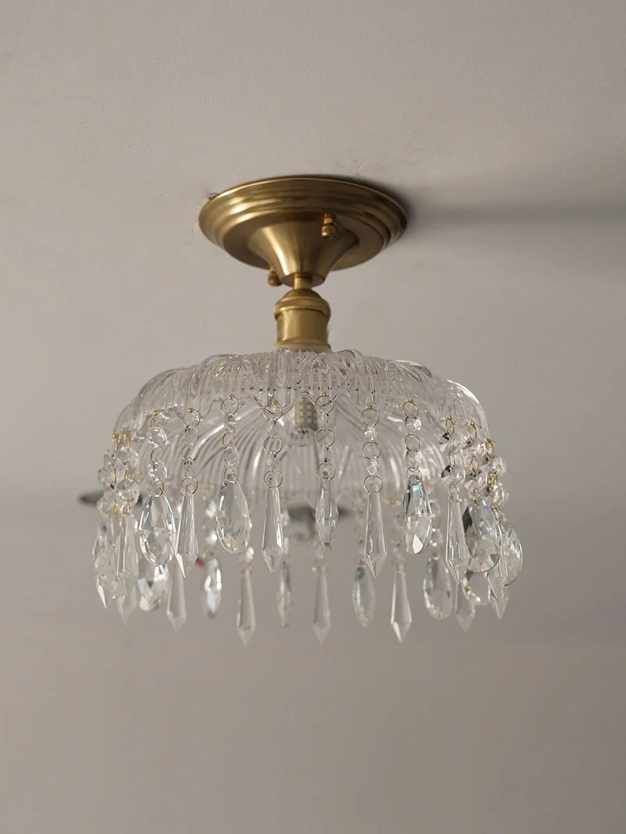 Ceiling light fixture with crystal design and gold finish on a neutral background