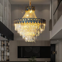 A wide shot of a sophisticated living room featuring a prominent gold tiered crystal chandelier as the central light fixture.