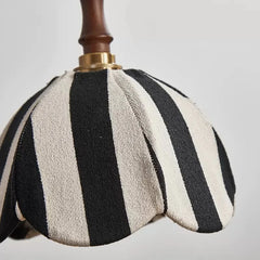Detailed view of the top of the pendant light, showing the connection between the wooden stem, brass hardware, and the fabric shade.