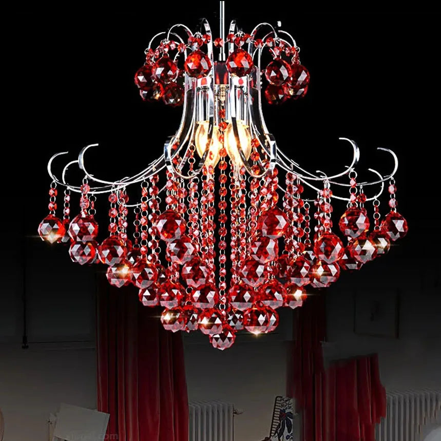 A cascading crystal chandelier with red crystals and a polished chrome frame against a black background.