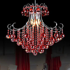 A cascading crystal chandelier with red crystals and a polished chrome frame against a black background.