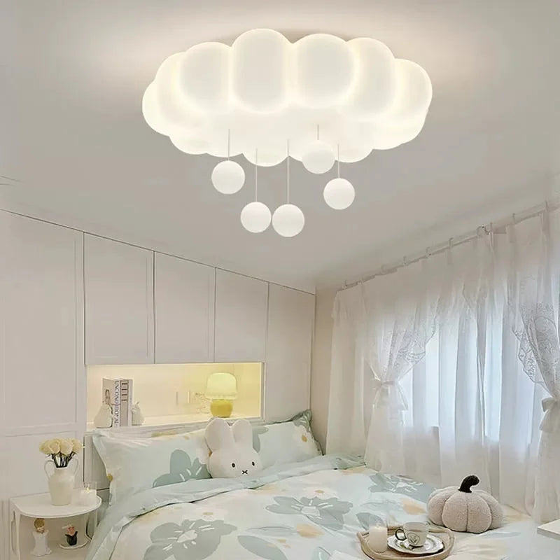 White cloud-shaped ceiling fixture with small white globe pendants, installed in a bedroom.