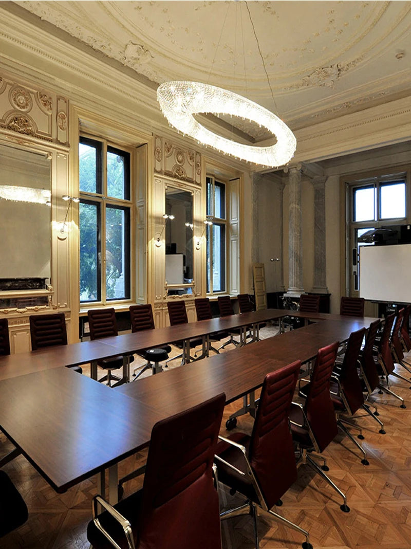 Large conference room with long tables and chairs, large windows, and decorative ceiling.