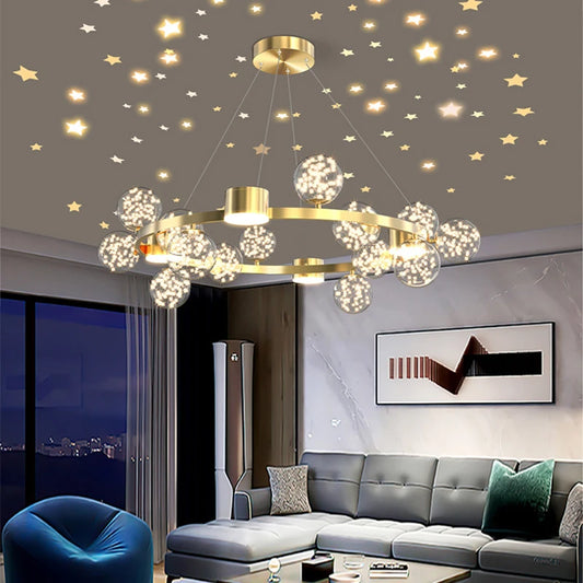 A modern gold chandelier with crystal-filled glass orbs and a starburst design hangs in a living room with star decals on the ceiling.