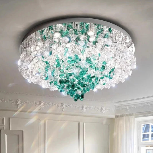A round, chrome-finished flush mount ceiling light adorned with cascading clear and green crystals.