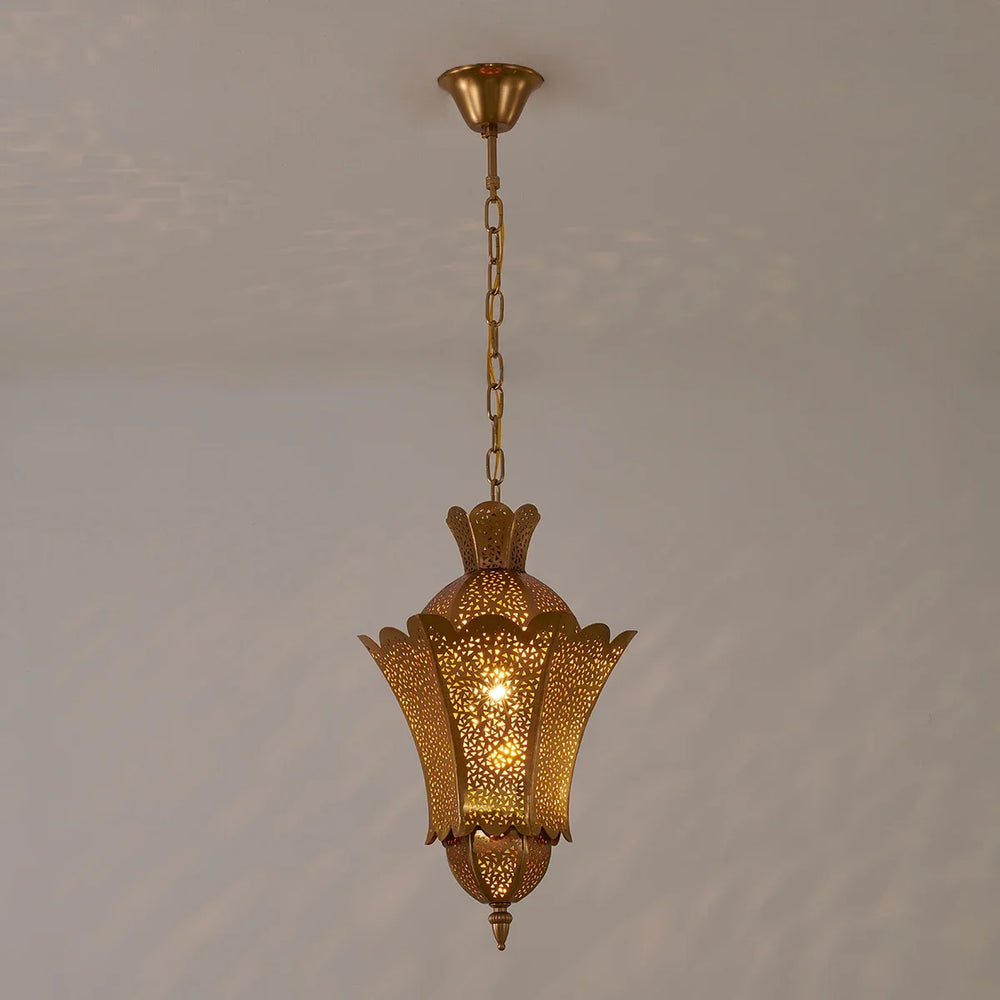 A gold hollow carved floral pendant light hanging from a chain against a plain background.