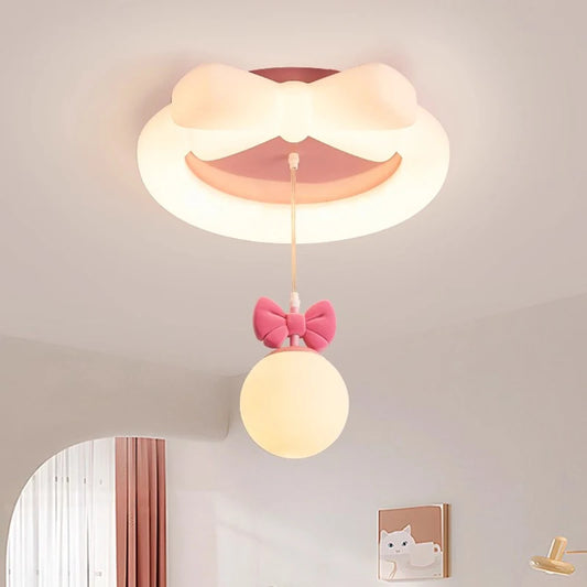 White ceiling light with a large pink bow on top and a small pink bow hanging with a white orb light, set against a white ceiling.