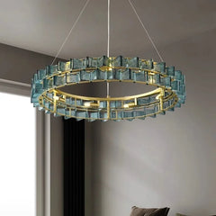 Gold ring chandelier with blue faceted glass crystals and gold frame, suspended by wires.