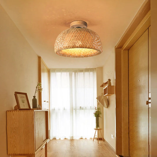 Woven bamboo dome ceiling light illuminating a hallway with wooden doors and a console table.