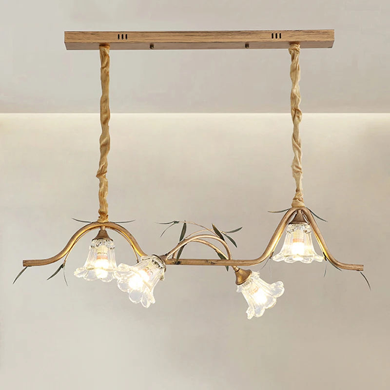 Close-up of a gold floral pendant light fixture showing the ornate metalwork and glass shades.