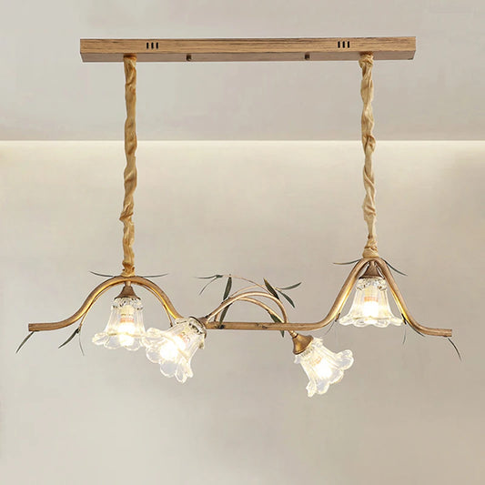 Close-up of a gold floral pendant light fixture showing the ornate metalwork and glass shades.