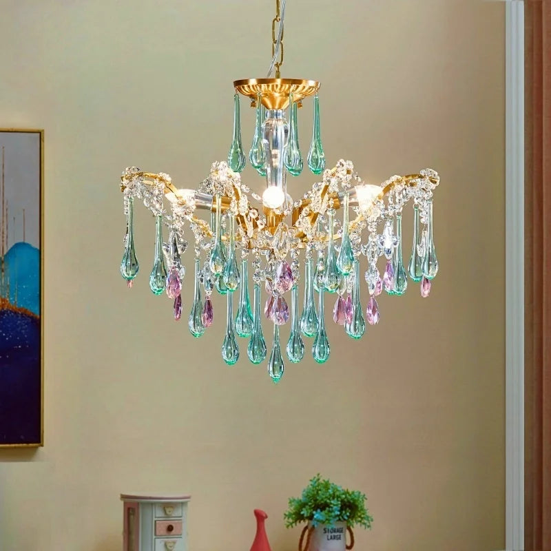 Gold teardrop crystal cascading chandelier with pink and green accents hanging in a well-lit room.