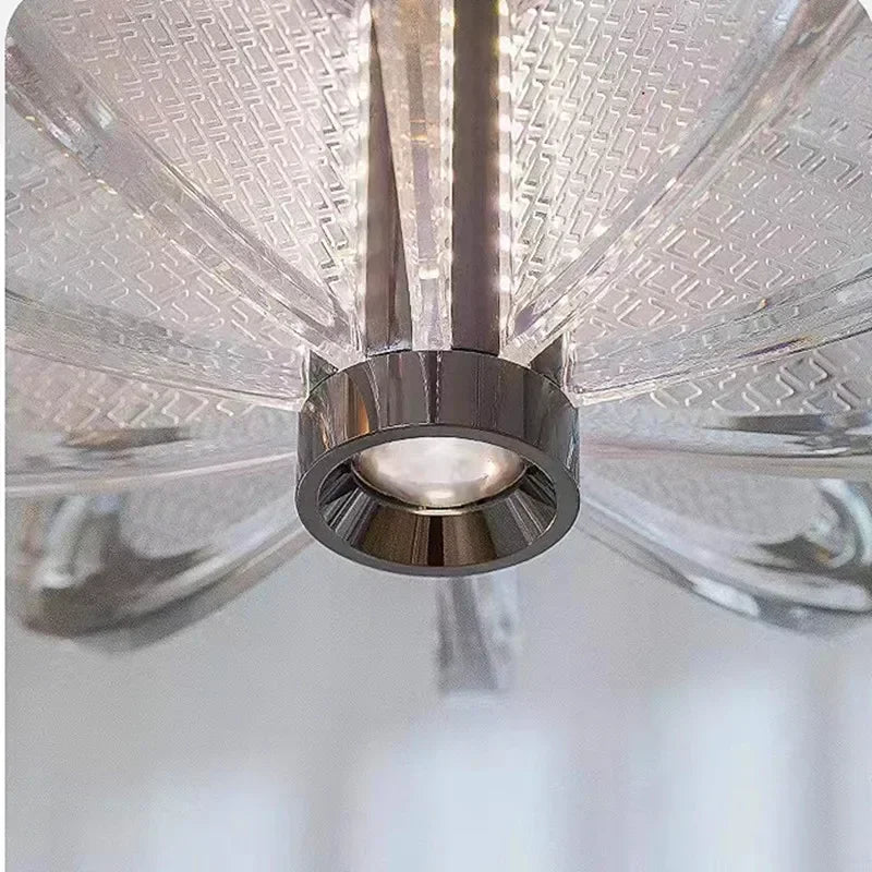 Close-up of a ceiling fan with clear blades and metallic hub.
