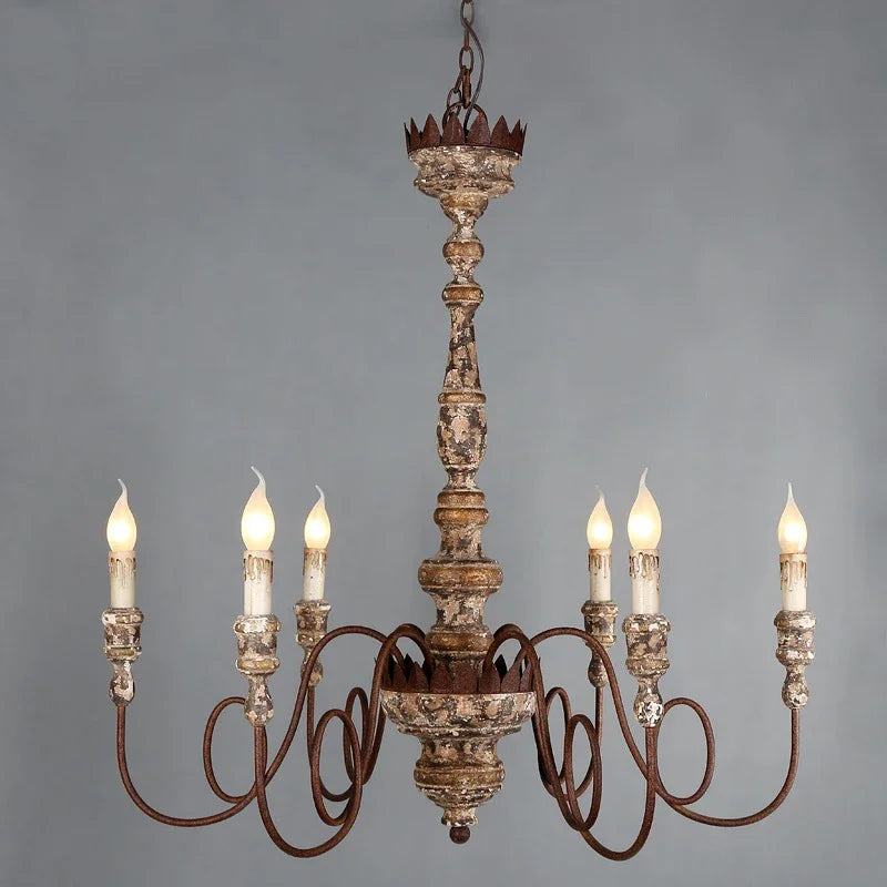 A distressed wood and iron candle-style chandelier with six faux candle lights against a gray background.