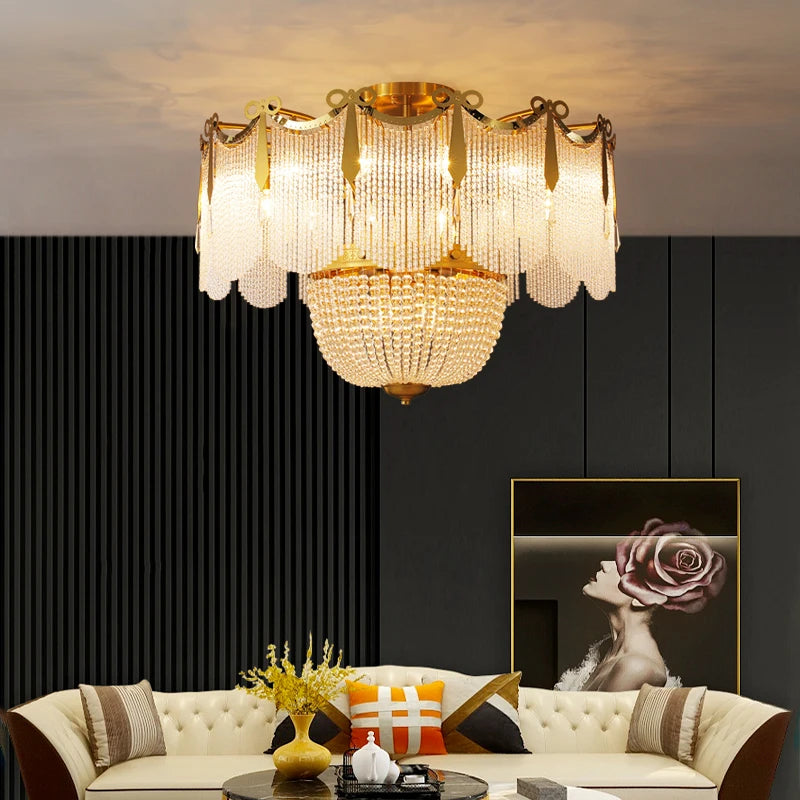 A gold and crystal tiered chandelier above a modern sofa and coffee table in a living room.