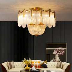 A gold and crystal tiered chandelier above a modern sofa and coffee table in a living room.