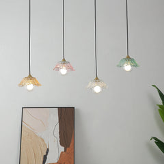 Close-up view of four colorful glass pendant lights hanging against a white wall.