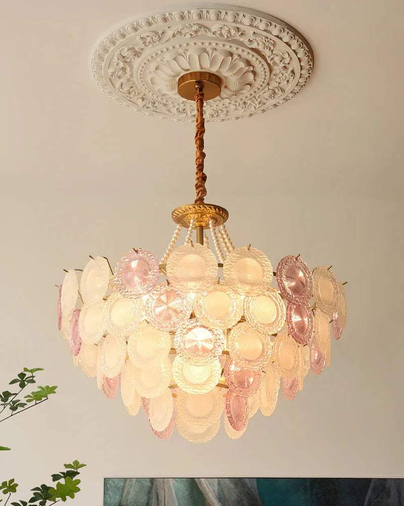 Decorative chandelier with pink and white shell-like design on a ceiling.