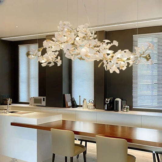 Close-up of a gold ginkgo leaf chandelier with ceramic leaves over a kitchen island