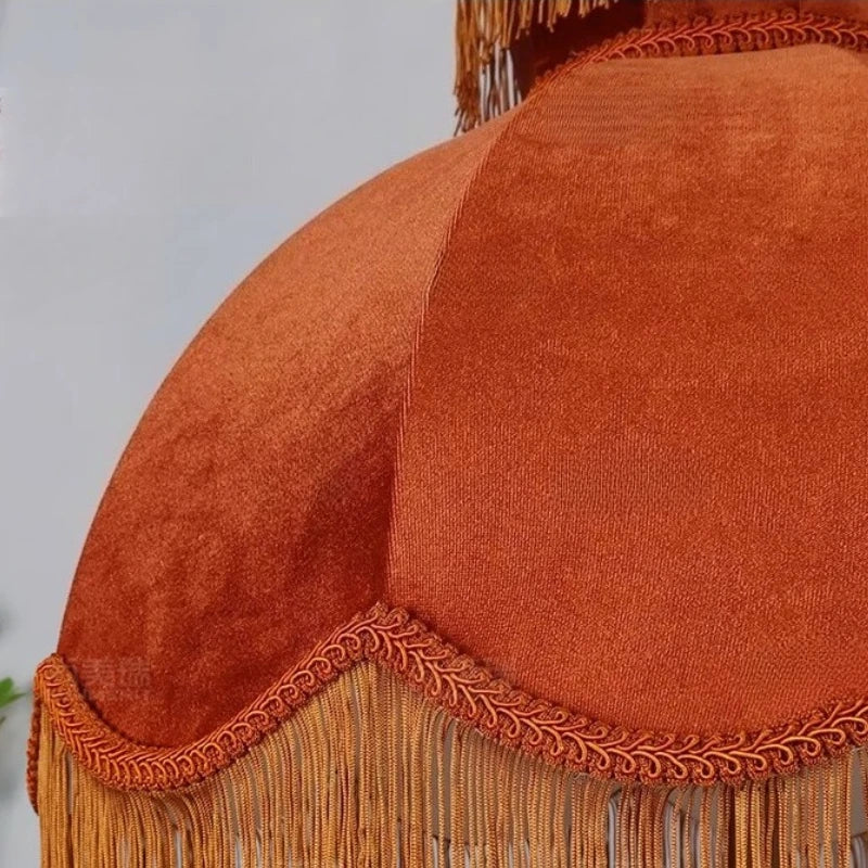 Close-up of an orange textured fabric with fringes on a plain background