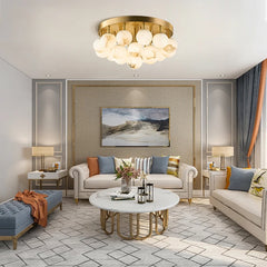A bright living room featuring a gold flush mount ceiling light with a cluster of marble-effect globes.