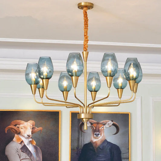 Gold chandelier with blue glass shades and artwork featuring anthropomorphic animals in the background.