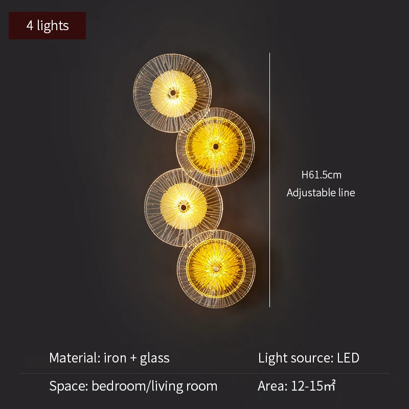 Wall-mounted light fixture with four illuminated circular lights on a dark background.