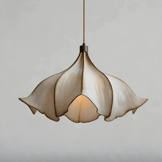 A close-up view of a single petal-shaped pendant light with a distressed finish.