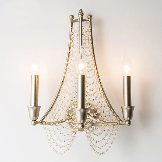 Silver metal wall sconce with three candle-style lights and cascading clear beads.