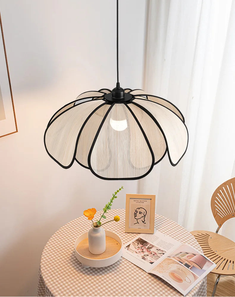 Modern pendant light fixture on a table with a white curtain background