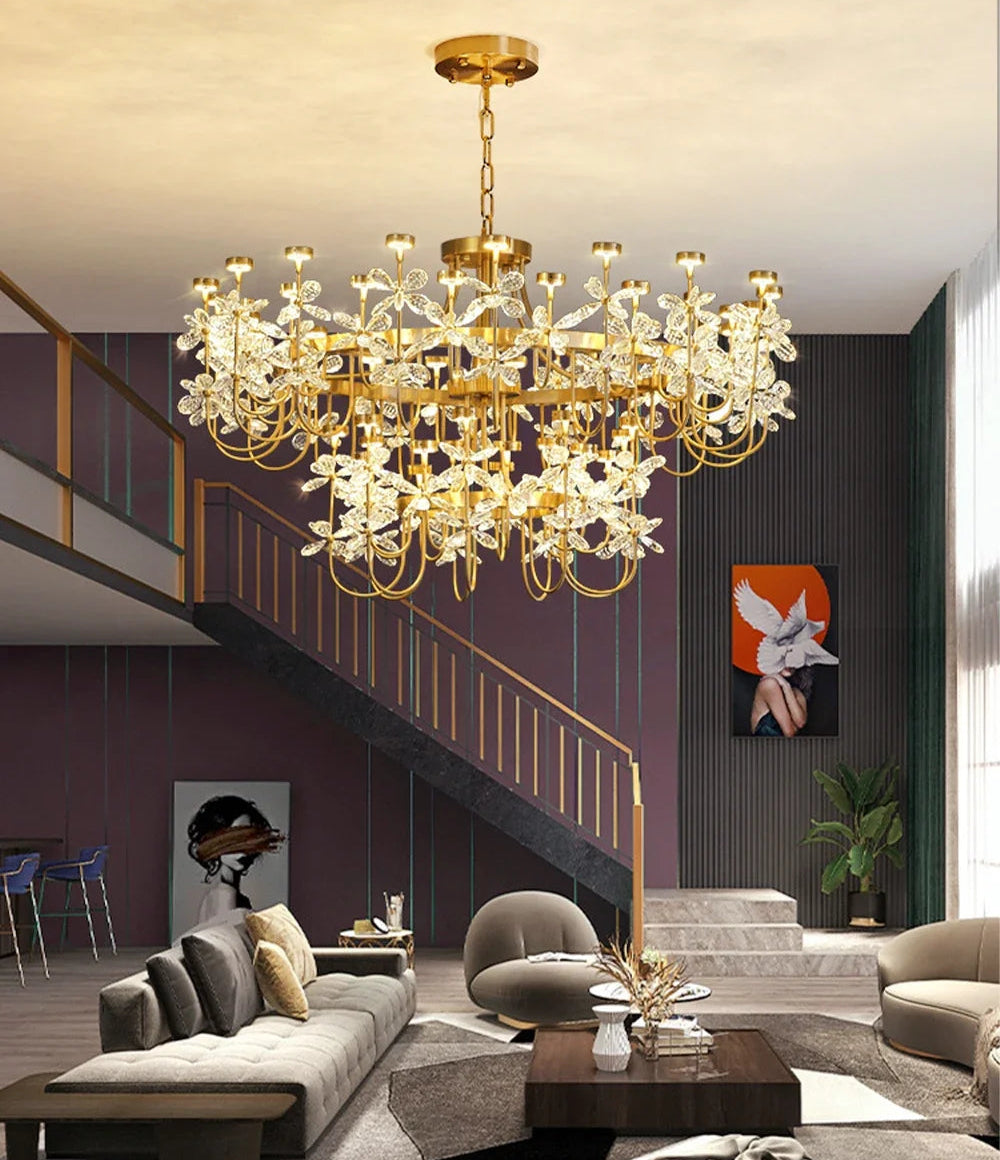 Luxurious living room with a gold chandelier, gray sofa, and decorative elements.