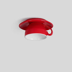 Side profile of a red ceramic coffee cup ceiling light fixture, highlighting its unique design and mounting on a white ceiling.