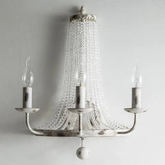 Silver chandelier with crystal accents on a plain background